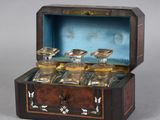 a wooden box with four glass jars inside of it