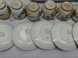 many plates and cups sitting on a table with a remote control