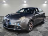 La voiture grise est garée sur le sol à damier du garage.