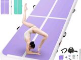 tapis de gymnastique gonflable violet et blanc sur lequel figure une femme faisant le poirier