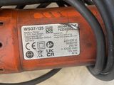 une perceuse rouge à laquelle est attaché un cordon noir