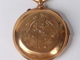 an image of a gold pocket watch on a white surface