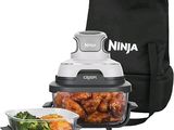 une friteuse Ninja avec du poulet et du brocoli à côté d'un sac-repas