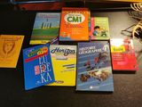 Plusieurs livres pour enfants sont posés sur une table, à côté d'une batte de baseball