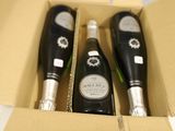 trois bouteilles de champagne dans un coffret avec une étiquette de prix
