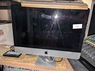 un écran d'ordinateur posé sur un bureau en bois