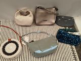 several purses and handbags are laid out on a table