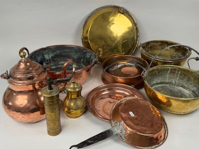 un grand nombre de casseroles et de poêles en cuivre posées sur une table