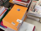 une pile de livres et de cahiers posée sur un bureau