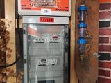 un distributeur automatique dans un coin d'une pièce, avec un skateboard accroché au mur