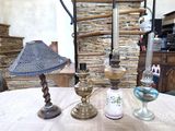 trois lampes posées sur une table devant un mur de pierre