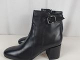 a pair of black leather ankle boots with buckles