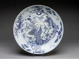 a blue and white plate with birds and flowers on it