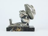 figurine en argent représentant une grenouille coiffée d'un chapeau et tenant un parapluie, posée sur un socle en marbre