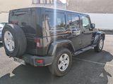 a black jeep parked in a parking lot next to a building