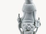 a white vase with a statue of a woman on it