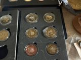several different coins are sitting on a counter top next to a bag