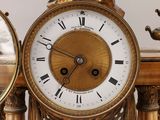 a gold clock with roman numerals on it