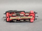 a small red train engine on a gray surface