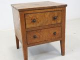 a small wooden table with two drawers on it
