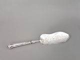 une cuillère ancienne en argent à long manche posée sur une surface grise