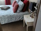 une chambre avec un lit et une table de chevet sur laquelle se trouve une lampe