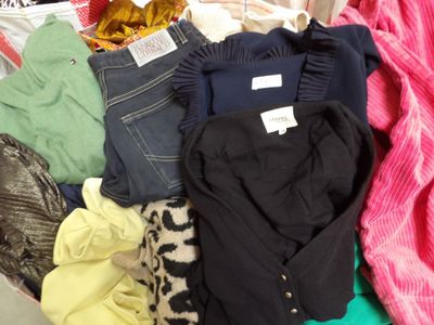 une pile de vêtements posée sur un lit