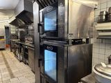a large kitchen with a lot of stainless steel appliances