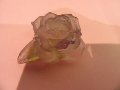 une fleur en verre posée sur une table, sur laquelle se projette une ombre
