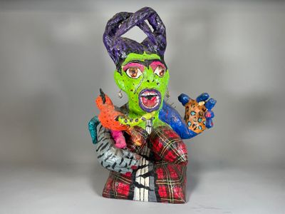 une figurine représentant une femme au visage vert et aux cheveux violets