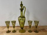 quatre verres et une carafe posés sur une table
