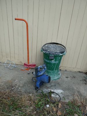 a green trash can and a blue fire hydrant on the side of a building