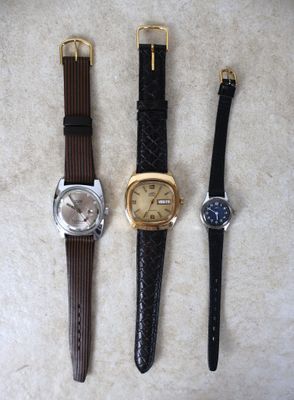 Trois types de montres différents sont alignés sur une table