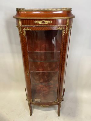 une vitrine ancienne en bois, dotée de portes vitrées et de garnitures dorées