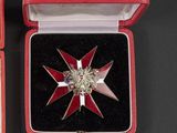 a red box with a silver and red star brooch on it