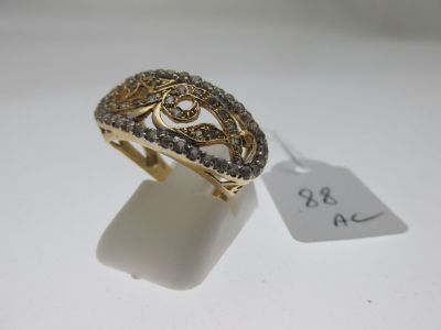 gros plan d'une bague en or avec des diamants sur une surface blanche