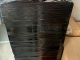 a large stack of black plastic boxes on the floor