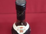 a bottle of liquor sitting on a red surface