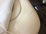 a white couch with a white blanket on top of it