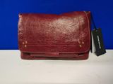 red leather purse with a tag on it sitting on a table