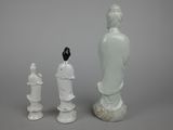 two white figurines of a woman and a man on a gray background