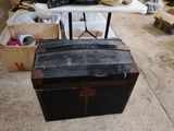 an old trunk sitting on the floor next to a table