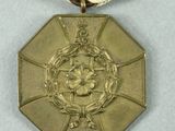medals are displayed on a white surface with a red, yellow, and white ribbon