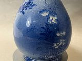 un vase bleu et blanc posé sur une table