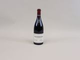 la bouteille de vin est posée sur une surface blanche