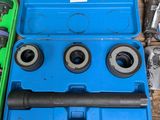 une boîte à outils bleue contenant des outils, posée sur une table en bois