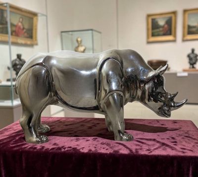a rhino statue sitting on a table in a museum