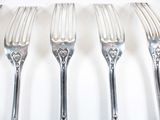 four forks that are sitting on a white table