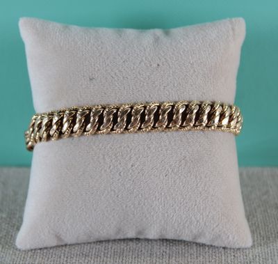 un bracelet en chaîne d'or posé sur un coussin