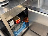 stainless steel counter top in a commercial kitchen with a mixer and other appliances